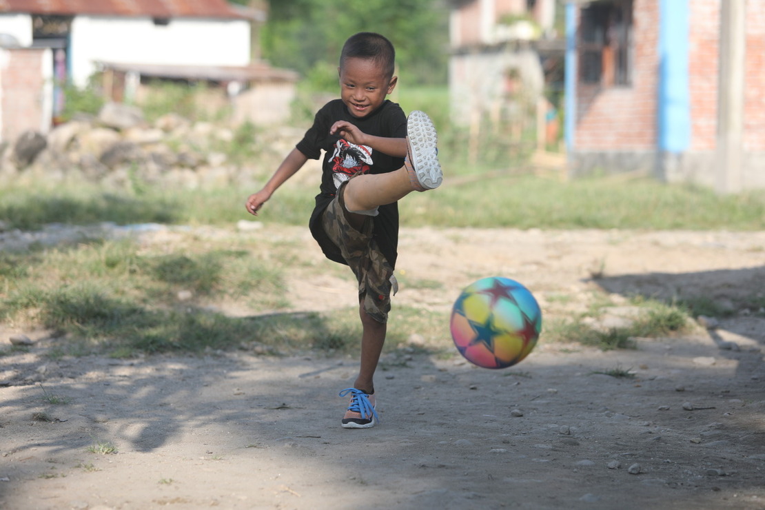 A little boy fitted with prosthetics is playing football Humanity & Inclusion Nepal Projects